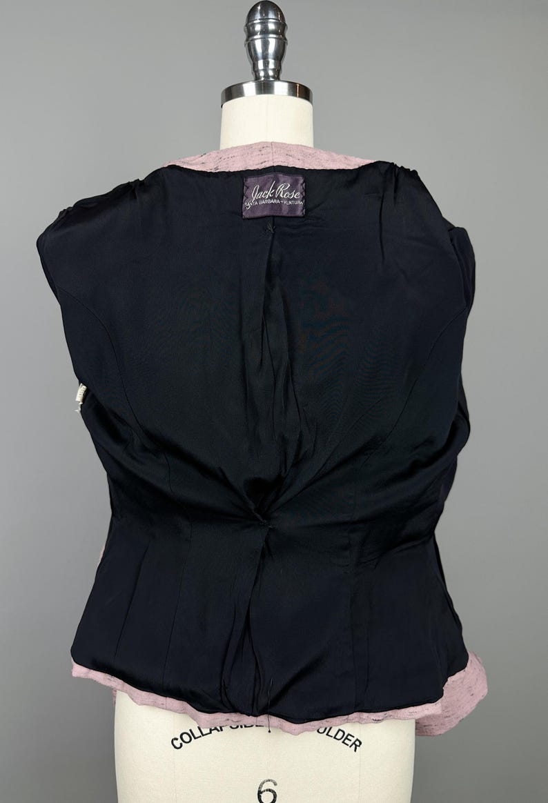 Puede incluir: Vista posterior de una chaqueta de mujer rosa y negra con una etiqueta que dice "Jack Rose, Santa Barbara, Ventura".