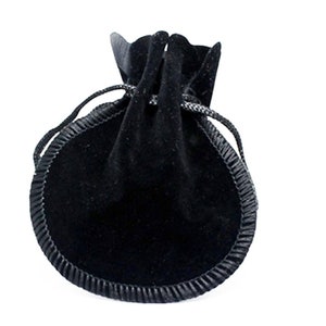 May include: A black velvet drawstring pouch with a black satin trim. The pouch is closed and appears to be empty.