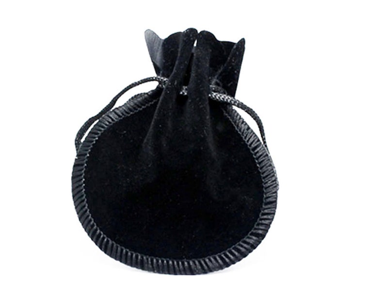 May include: A black velvet drawstring pouch with a black satin trim. The pouch is closed and appears to be empty.