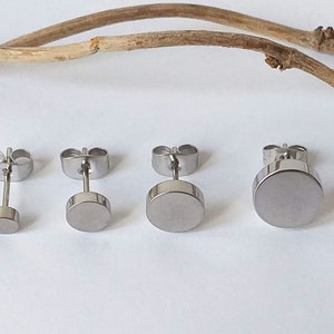Könnte beinhalten: Vier Paar silberne Ohrstecker mit unterschiedlich großen runden Scheiben. Die Ohrringe sind nach Größe sortiert, vom kleinsten zum größten.