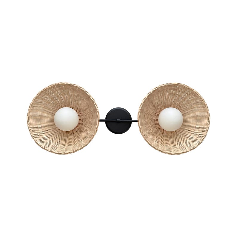 May include: A black metal wall sconce with two woven wicker shades and white globe light bulbs.