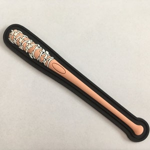 May include: A black and white baseball bat with a barbed wire design. The bat is made of plastic and is about 18 inches long.