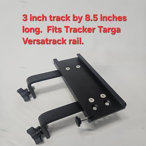 May include: Black metal track, 3 inches wide by 8.5 inches long, with two adjustable clamps and mounting hardware. The text in the image reads: "3 inch track by 8.5 inches long. Fits Tracker Targa Versatrack rail."