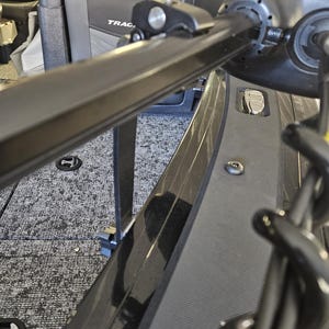 Puede incluir: Un portaca&ntilde;as de barco de metal negro con una perilla plateada y una correa negra. El portaca&ntilde;as est&aacute; montado en el lateral de un barco. El barco tiene un suelo de alfombra gris y una moldura negra.