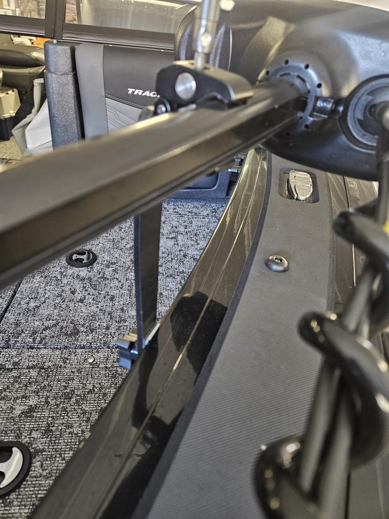 Puede incluir: Un portaca&ntilde;as de barco de metal negro con una perilla plateada y una correa negra. El portaca&ntilde;as est&aacute; montado en el lateral de un barco. El barco tiene un suelo de alfombra gris y una moldura negra.