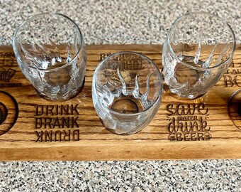 May include: Wooden serving tray with four glass shot glasses and two metal shot glasses. The tray has engraved text that reads "Save Water Drink Beers" and "Drink Drank Drunk".