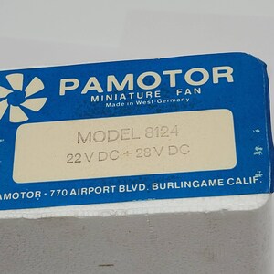 May include: A close-up of a blue and white box with the text "PAMOTOR MINIATURE FAN" and "Made in West-Germany." The box also displays "MODEL 8124" and "22 V DC &divide; 28 V DC."