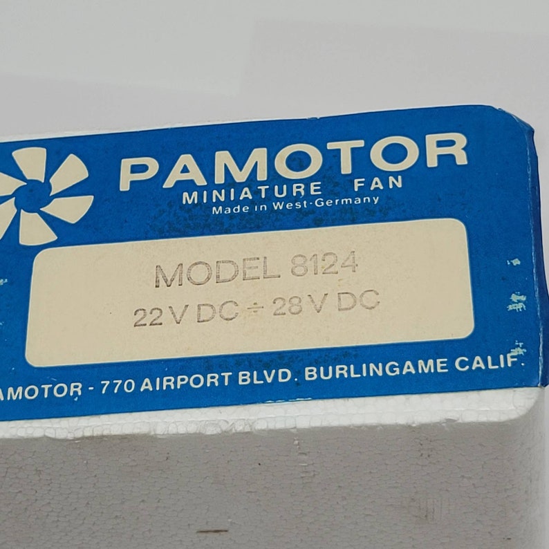 May include: A close-up of a blue and white box with the text "PAMOTOR MINIATURE FAN" and "Made in West-Germany." The box also displays "MODEL 8124" and "22 V DC &divide; 28 V DC."