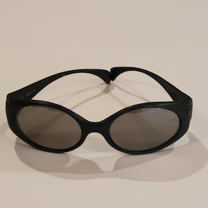 May include: Black sunglasses with round lenses and a thick black frame.