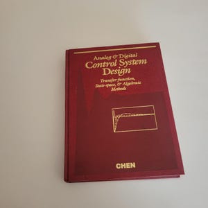 Puede incluir: Un libro granate titulado "Analog & Digital Control System Design". La portada presenta letras doradas y un diagrama. El nombre del autor, CHEN, está en la parte inferior. El subtítulo del libro es "Transfer-function, State-space, & Algebraic Methods."