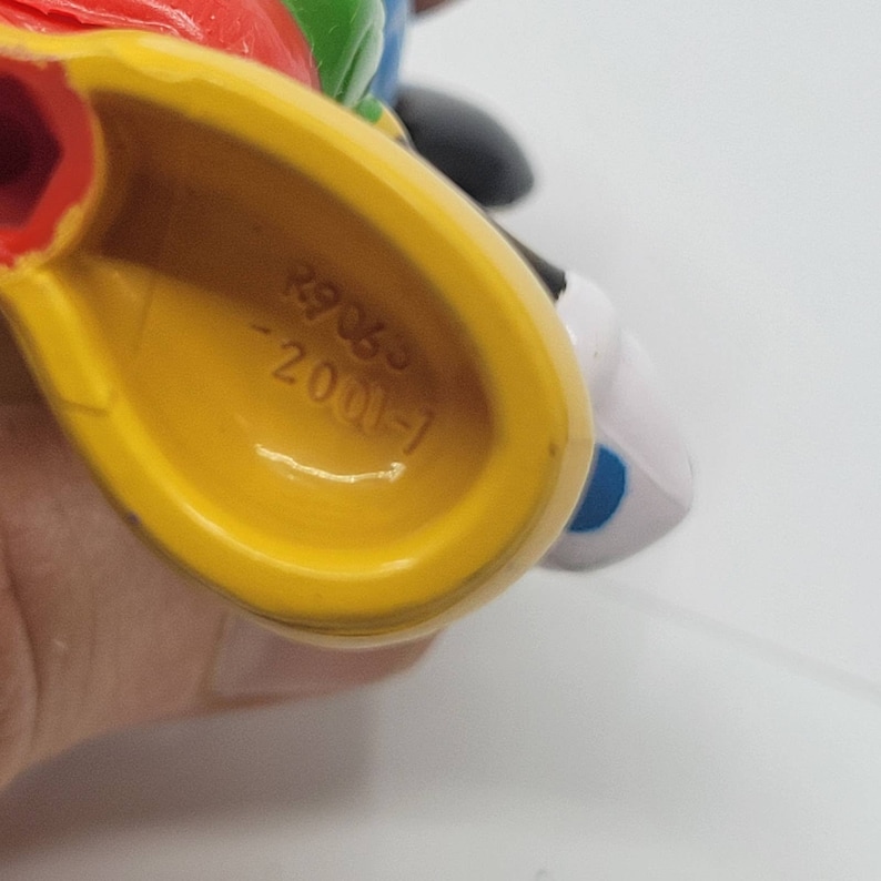 May include: Yellow plastic toy with the text "1-1000-6302" on the bottom.