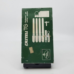 May include: A green box set of Castell TG technical pens and accessories. The box features the brand name and product details in white. The set includes several pens, a compass, and other drafting tools, ideal for technical drawing and design.