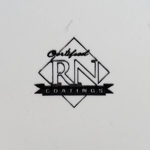 May include: A black and white logo on a white background. The logo features the letters "RN" inside a diamond shape, with the word "Coatings" below. Above the diamond is the word "Certified".