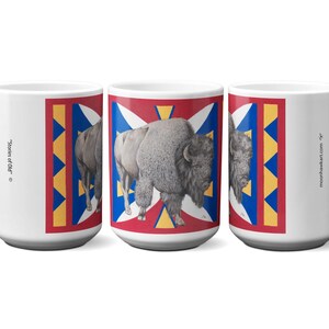 May include: White ceramic mug featuring a bison illustration on a red, white, blue, and yellow geometric design. The mug has the text "Stories of Old" and "moonhawkart.com" printed on it.