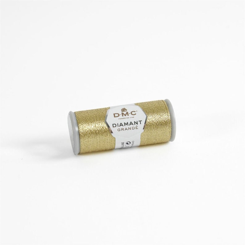 May include: A spool of gold metallic thread labeled "DMC Diamant Grande" for embroidery and crafting.