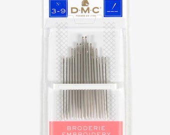 Puede incluir: Un paquete de agujas de bordar DMC. El embalaje de plástico transparente tiene una etiqueta blanca y roja con el texto "BRODERIE EMBROIDERY BORDADO" y "16 AIGUILLES NEEDLES AGUJAS". Las agujas son plateadas y de tamaños 3-9.