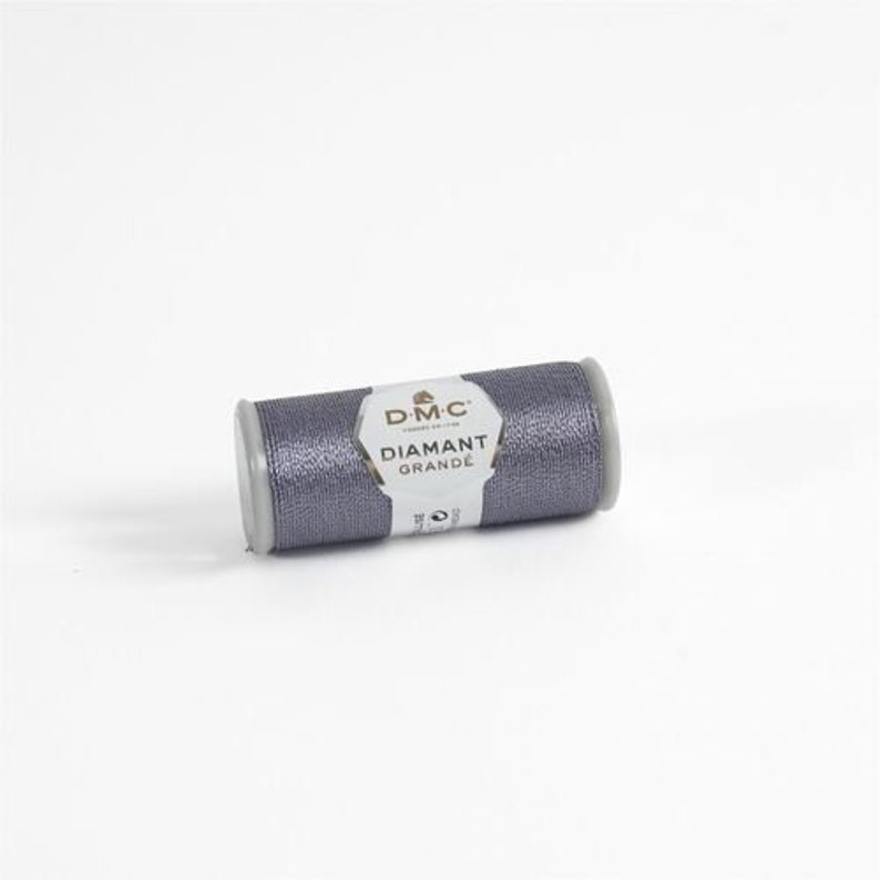 May include: A spool of DMC Diamant Grande embroidery thread in a silver gray color.