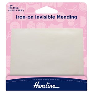Op de afbeelding: Een witte, strijkbare onzichtbare reparatiepleister, 40 cm bij 50 cm, verpakt in een roze en blauwe doos met de tekst "Iron-on Invisible Mending" en "Hemline".
