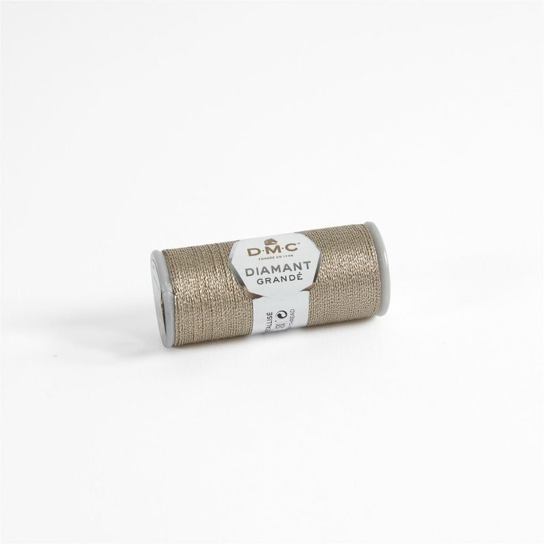 May include: A spool of gold metallic thread labeled "DMC Diamant Grande" for embroidery and crafting.