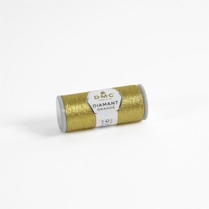 May include: A gold spool of DMC Diamant Grande embroidery thread. The spool is labeled with the DMC logo and the text "Diamant Grande".