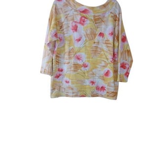 Peut inclure: Un haut &agrave; manches trois-quarts avec un col rond. Le tissu jaune est orn&eacute; de motifs floraux roses, blancs et bruns. La mati&egrave;re semble douce et l&eacute;g&egrave;re, adapt&eacute;e aux temp&eacute;ratures plus chaudes.