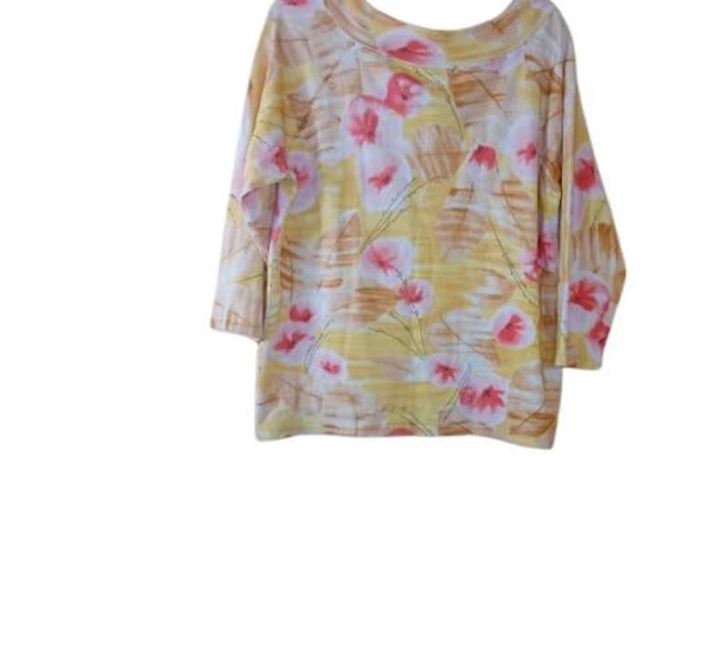 Peut inclure: Un haut &agrave; manches trois-quarts avec un col rond. Le tissu jaune est orn&eacute; de motifs floraux roses, blancs et bruns. La mati&egrave;re semble douce et l&eacute;g&egrave;re, adapt&eacute;e aux temp&eacute;ratures plus chaudes.
