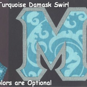 May include: Two fabric letters, A and M, in a turquoise damask pattern with a gray border. The letters are on a black background. The text "#1524 Shades of Turquoise Damask Swirl" is at the top of the image. The text "Border Colors are Optional" is at the bottom of the image.