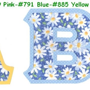 May include: Two fabric letters, A and B, with a white daisy pattern on a blue background. The letter A has a yellow border and the letter B has a light blue border.