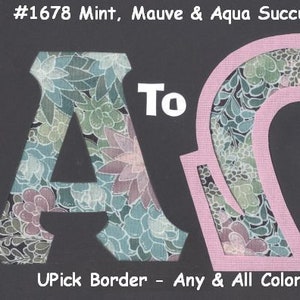 May include: A floral patterned fabric cut out in the shape of the letters "To" and "AQ". The letters are pink and the fabric is a mix of green, blue, and purple.