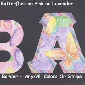 May include: Two fabric letters, B and A, with a glittery butterfly pattern on pink and lavender backgrounds. The letters have a striped border and the text "U-Pick Border - Any/All Colors Or Stripe" is below the letters.