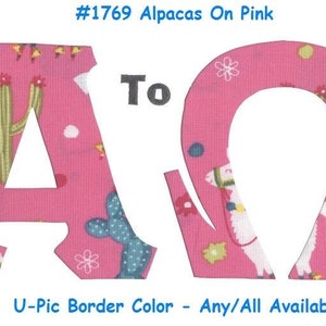 May include: Two fabric letters, A and Q, in pink with a white background and a pattern of alpacas and cacti. The letters are cut out and have a white border. The text "#1769 Alpacas On Pink" and "To" are above the letters. The text "U-Pic Border Color - Any/All Available" is below the letters.