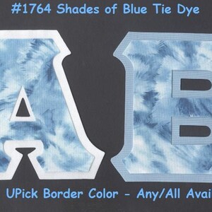 May include: Two large letters, A and B, are cut out of white fabric and backed with blue tie-dye fabric. The letters have a white border. #1764 Shades of Blue Tie Dye. UPick Border Color - Any/All Available