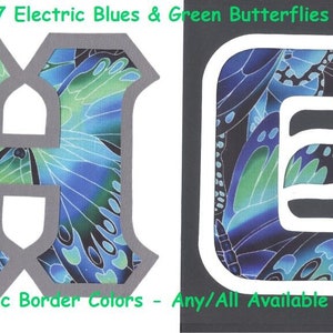 May include: Two fabric letters, H and E, with a blue and green butterfly pattern. The letters have a gray border. The text #1747 Electric Blues & Green Butterflies is at the top of the image. The text U-Pic Border Colors - Any/All Available is at the bottom of the image.
