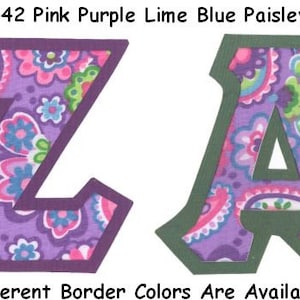 May include: Two fabric letters, Z and A, in a purple and pink paisley pattern with a dark purple and green border. The letters are outlined in a darker shade of purple and green. The text #1542 Pink Purple Lime Blue Paisley is at the top of the image. The text Many Different Border Colors Are Available - UPick is at the bottom of the image.