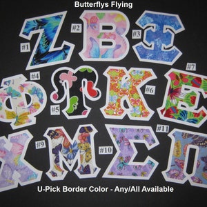 Puede incluir: Once letras de tela con diseños de mariposas en varios colores, incluyendo rosa, azul, verde, amarillo y morado. Las letras están numeradas del 1 al 11. El texto "Butterflys Flying" está en la parte superior de la imagen. El texto "U-Pick Border Color - Any/All Available" está en la parte inferior de la imagen.