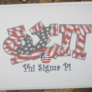 May include: White card with the Greek letters Phi Sigma Pi in red and white stripes and stars, resembling the American flag. A small circular emblem of the American flag is below the letters. The words "Phi Sigma Pi" are written in blue.