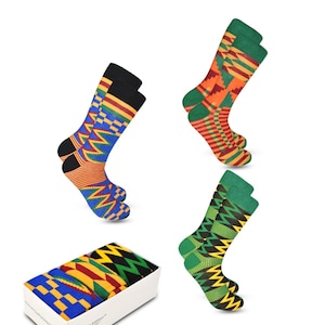 May include: A set of three pairs of colorful socks with geometric patterns in shades of green, yellow, red, and blue. The socks are packaged in a white box with the text "Sankofa Edition" printed on the side.