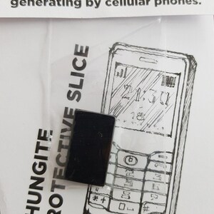 Puede incluir: Una rebanada protectora de shungita negra, diseñada para proteger contra los campos electromagnéticos generados por los teléfonos móviles. La imagen muestra un dibujo de un teléfono móvil con la rebanada de shungita colocada sobre la pantalla.