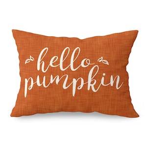 May include: Orange throw pillow with the text "hello pumpkin" in white cursive lettering.