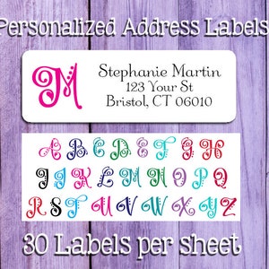 May include: A sheet of 30 personalized address labels with a decorative initial letter design. The labels feature a sample address with the name Stephanie Martin, 123 Your St, Bristol, CT 06010. The image also shows a selection of 26 decorative initial letters in various colors.