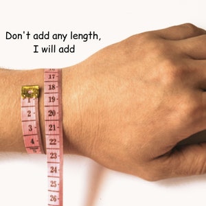 May include: A pink measuring tape is wrapped around a person's wrist. The tape reads "Don't add any length, I will add" and shows measurements from 17 to 26 inches.