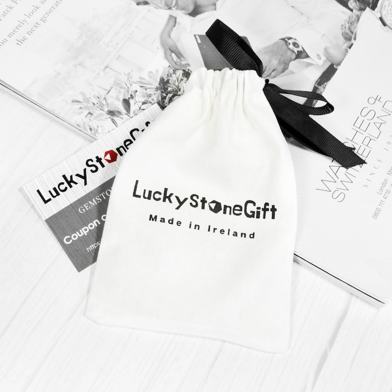 May include: A white drawstring bag with a black ribbon and the text "Lucky Stone Gift Made in Ireland".