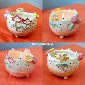 May include: Four ceramic candle holders with floral designs. Each holder has a different floral pattern and color scheme, including pink, yellow, and green. The holders are all white with a textured surface. The candle holders are perfect for adding a touch of elegance to any home.