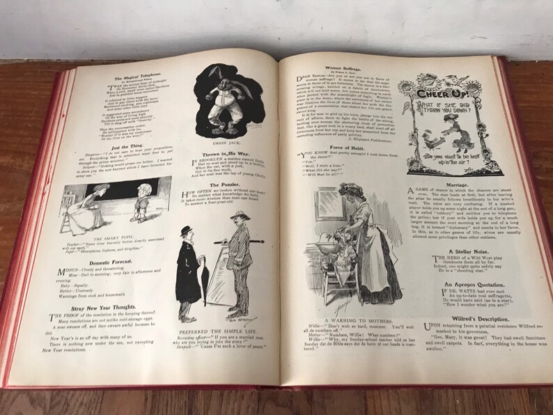 May include: An open book with black and white illustrations and text. The book is open to a page with the title "Cheer Up!" and a cartoon of a woman sitting on a bench with a dog. The text on the page reads "What if she did throw you down?" and "Do you think we'd be the best, if you were in the cart?"