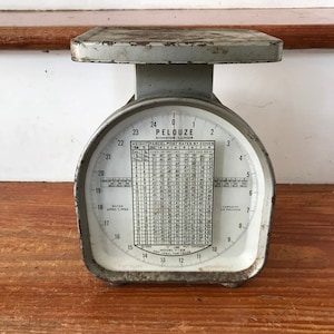 Puede incluir: Una báscula vintage de color plateado Pelouze con un dial blanco y una tabla de tarifas postales para paquetes por zonas. La báscula tiene una capacidad de 11,3 kg.