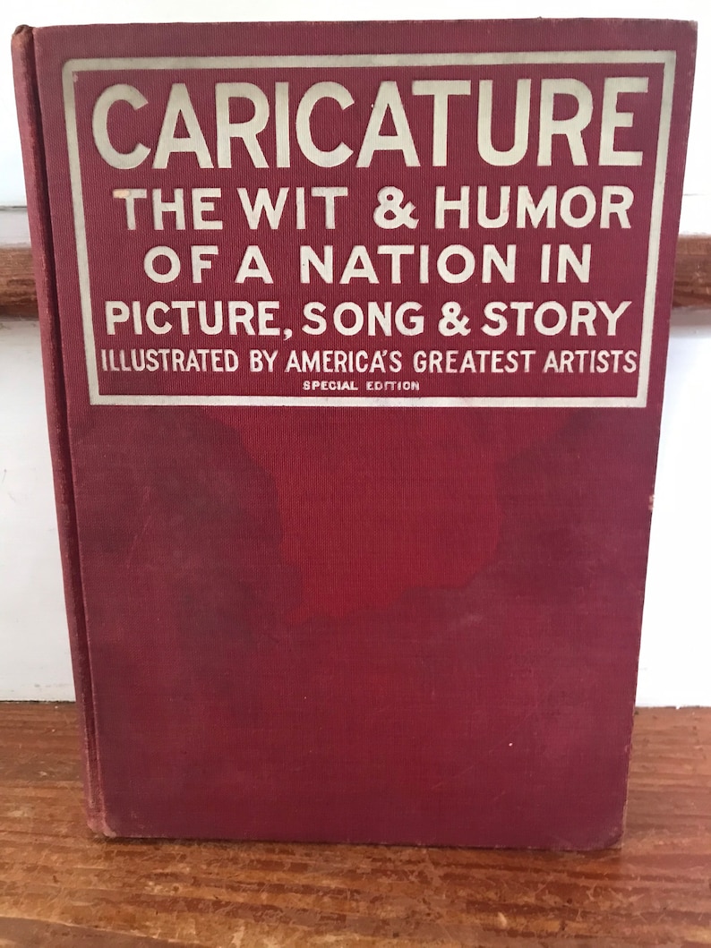 May include: A red book with the title "CARICATURE THE WIT & HUMOR OF A NATION IN PICTURE, SONG & STORY ILLUSTRATED BY AMERICA'S GREATEST ARTISTS SPECIAL EDITION"