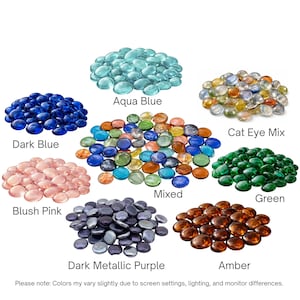 May include: A collection of glass gems in various colors labeled Aqua Blue, Cat Eye Mix, Dark Blue, Mixed, Green, Blush Pink, Dark Metallic Purple, and Amber. The text states: Please note: Colors may vary slightly due to screen settings, lighting, and monitor differences.