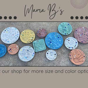 May include: Handprint and footprint keepsakes in various colors, including blue, yellow, and pink. Each piece features a child's handprint or footprint, with names and decorative accents. The image includes the text "Mama B's" and "Visit our shop for more size and color options!"