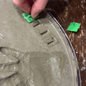 Child decorating his footprint stepping stone kit with mosaic glass gems. Children love making these easy to d kits!