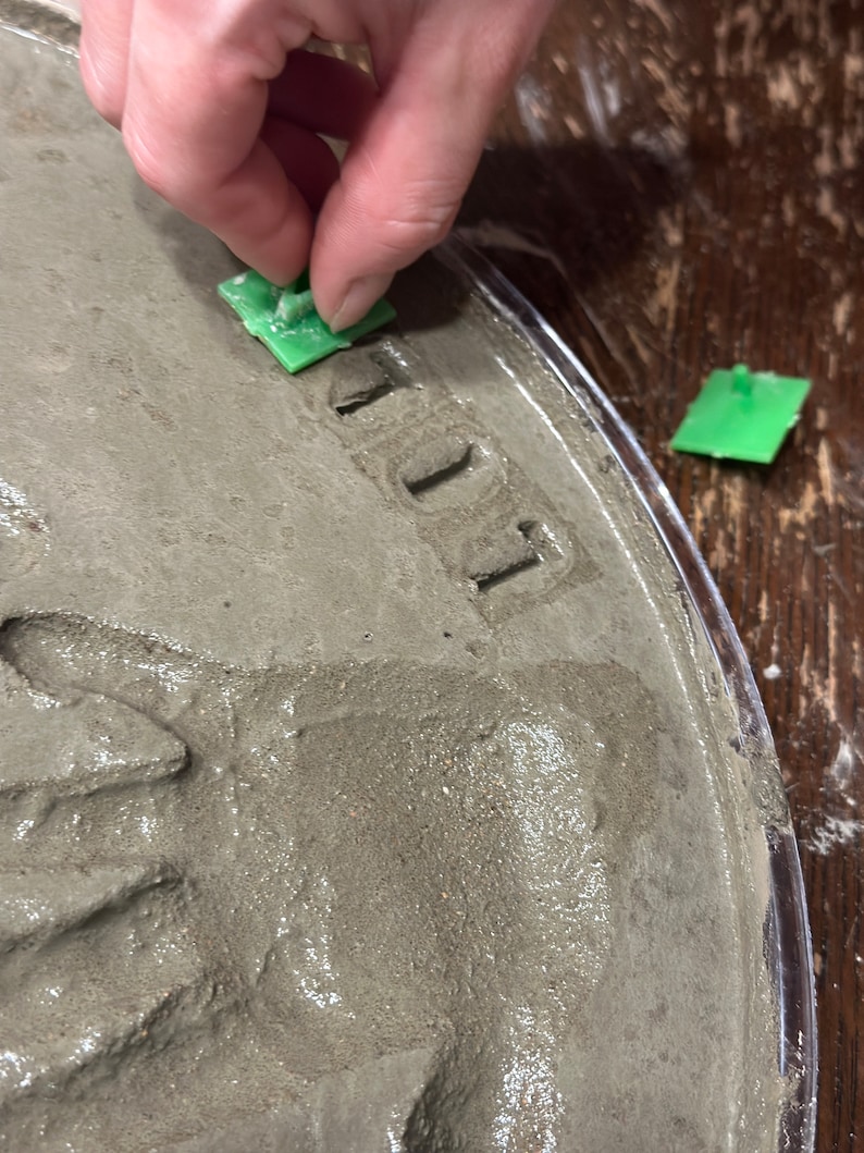 Child decorating his footprint stepping stone kit with mosaic glass gems. Children love making these easy to d kits!